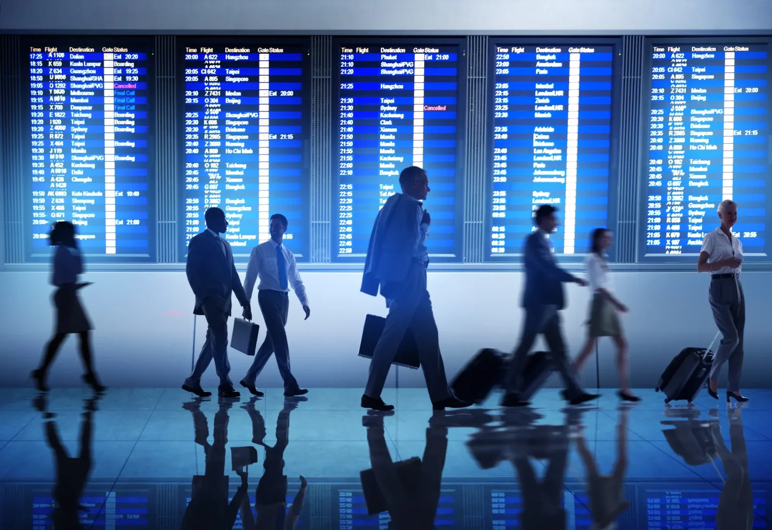 Business people at the gate, illuminated by the blue glow of departure screens